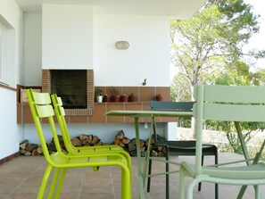Enjoy dining or socializing in this outdoor patio area with a brick fireplace and comfortable seating.