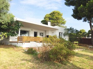 Enjoy a serene outdoor space with a large window, wooden deck, and well-maintained lawn.