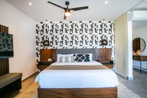 A modern bedroom with a large bed, a ceiling fan, and a patterned wall. - Two Pools, Bar & Gym | Casa Medianoche at Oasis (Puerto Vallarta)