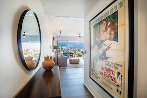 A modern living room with a large mirror, a coffee table, and a poster on the wall. - Two Pools, Bar & Gym | Casa Medianoche at Oasis (Puerto Vallarta)