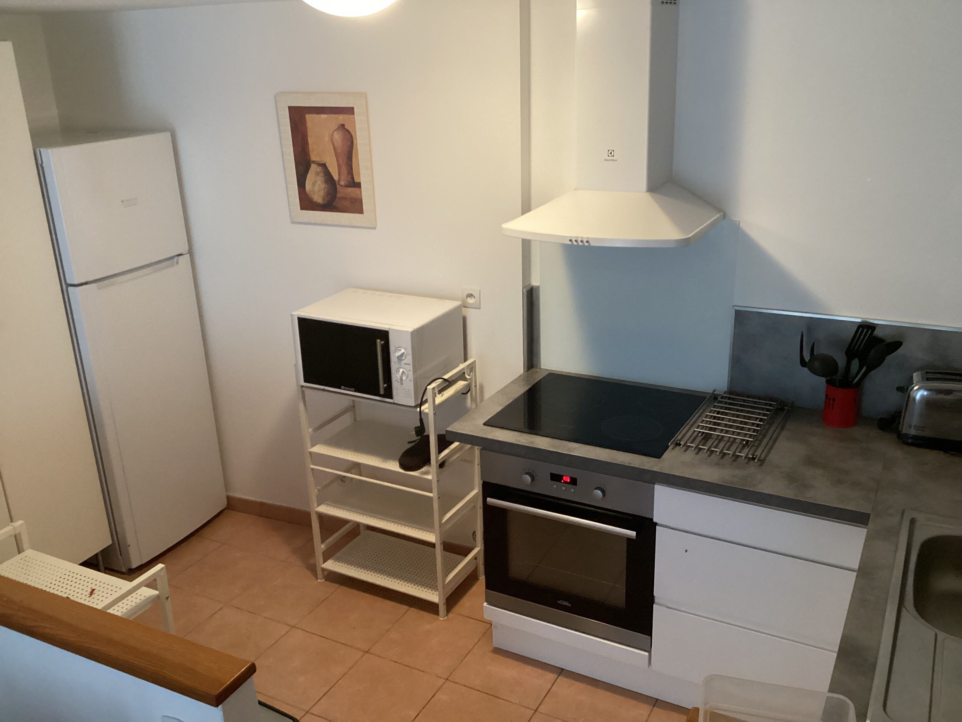 Una cocina funcional equipada con microondas, horno y cocina a gas.
