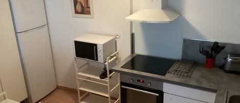 Una cocina funcional equipada con microondas, horno y cocina a gas.