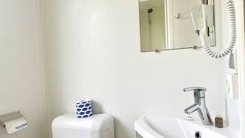 Un baño con inodoro, lavamanos y espejo.