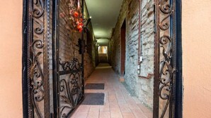 A narrow stone corridor with ornate metal gates and a tiled floor. - Casa Maya Transylvania Studio (Sighișoara)