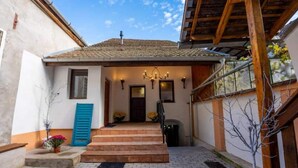 A building with a tiled roof, a wooden staircase, and a blue door. - Casa Maya Transylvania Studio (Sighișoara)