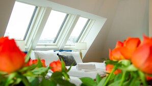 A hotel room with a bed, a nightstand, and a window with a view. - Grand Quarters City Residence (Vienna)