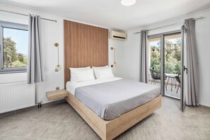 A modern bedroom with a large bed, wooden headboard, and a view of the outdoors.