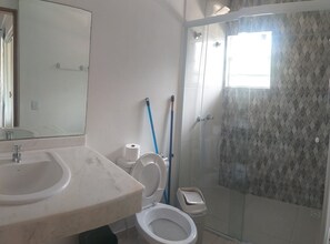 A bathroom with a marble sink, a toilet, and a glass-enclosed shower. - Plus Couple Suite with mini kitchen (Ilhabela)