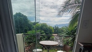 Ein Balkon mit Glastür, einem runden Tisch und zwei Stühlen.