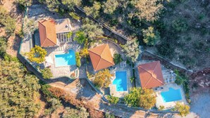 Vista aérea de una propiedad con dos piscinas, un patio cubierto y un camino de piedra.
