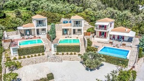 A modern villa with two swimming pools, a stone facade, and a lush green backdrop. - Villa Ira Lefkas - One Bedroom Villa, Sleeps 2 (Lefkada)