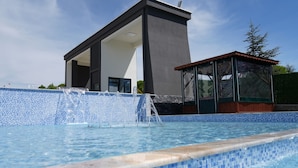 A modern building with a pool featuring blue mosaic tiles. - Villa Kent Termal Otel (Ihsaniye)