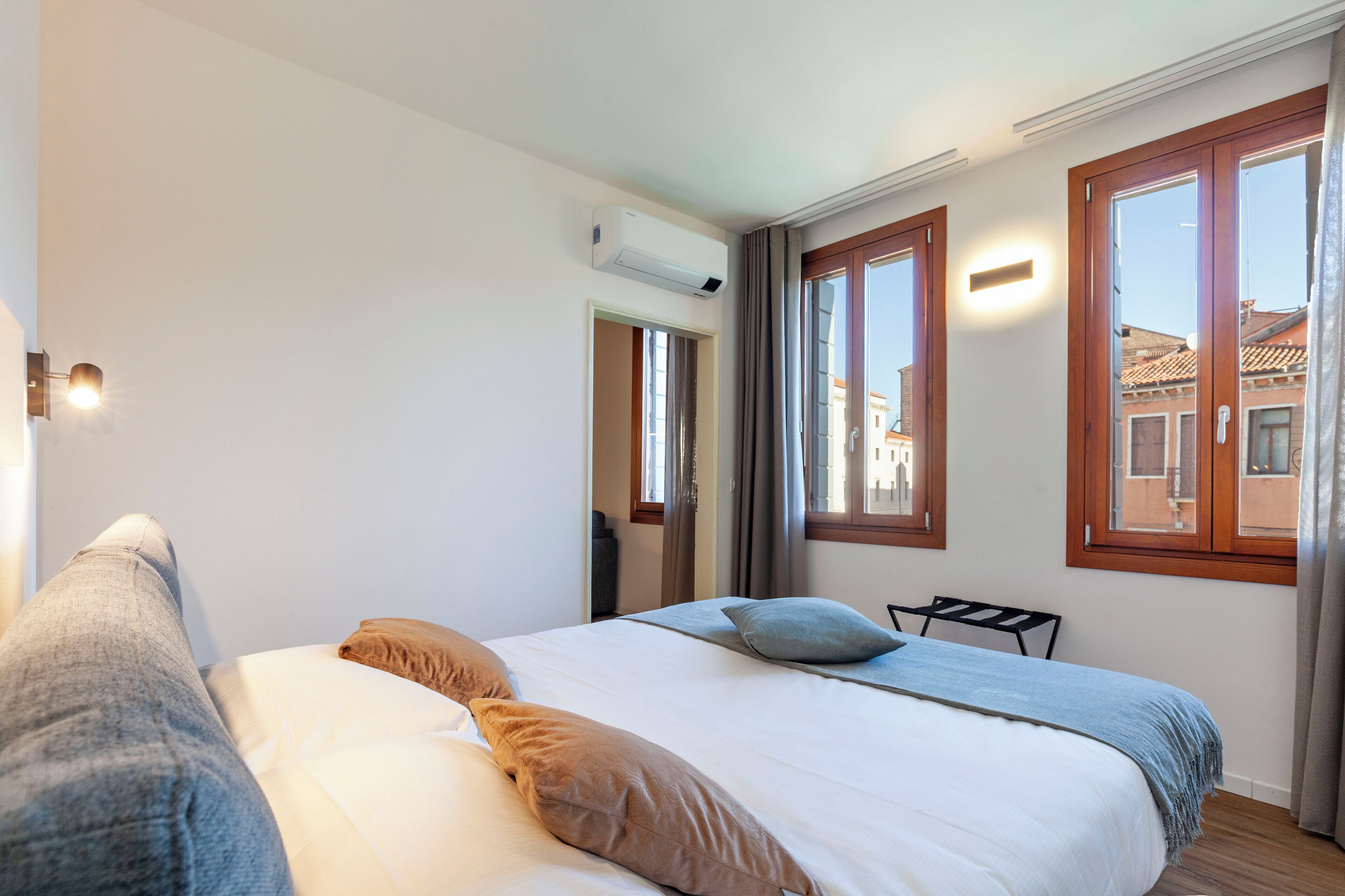 Une chambre à coucher avec un lit, une chaise et une fenêtre avec des rideaux.
