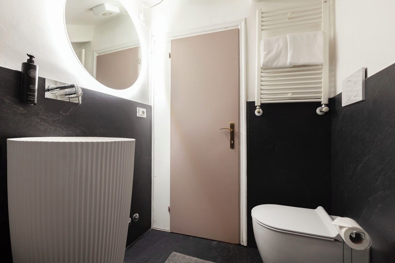 Un baño moderno con lavamanos blanco, inodoro y zona de ducha.