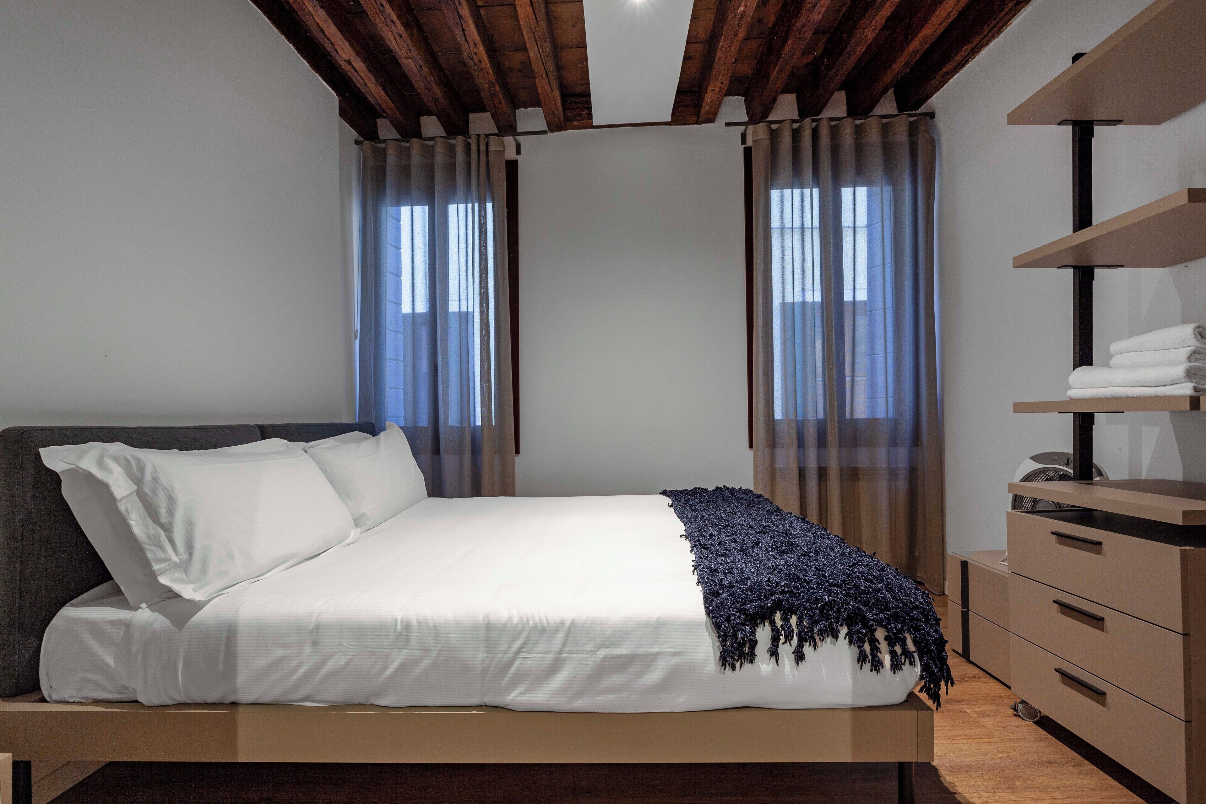 Une chambre à coucher moderne avec un lit, une commode et une bibliothèque intégrée.