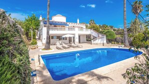 A large swimming pool with a white building in the background.