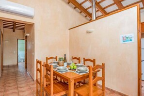 Enjoy meals in this cozy dining area with a table set for four, featuring a centerpiece and comfortable seating.