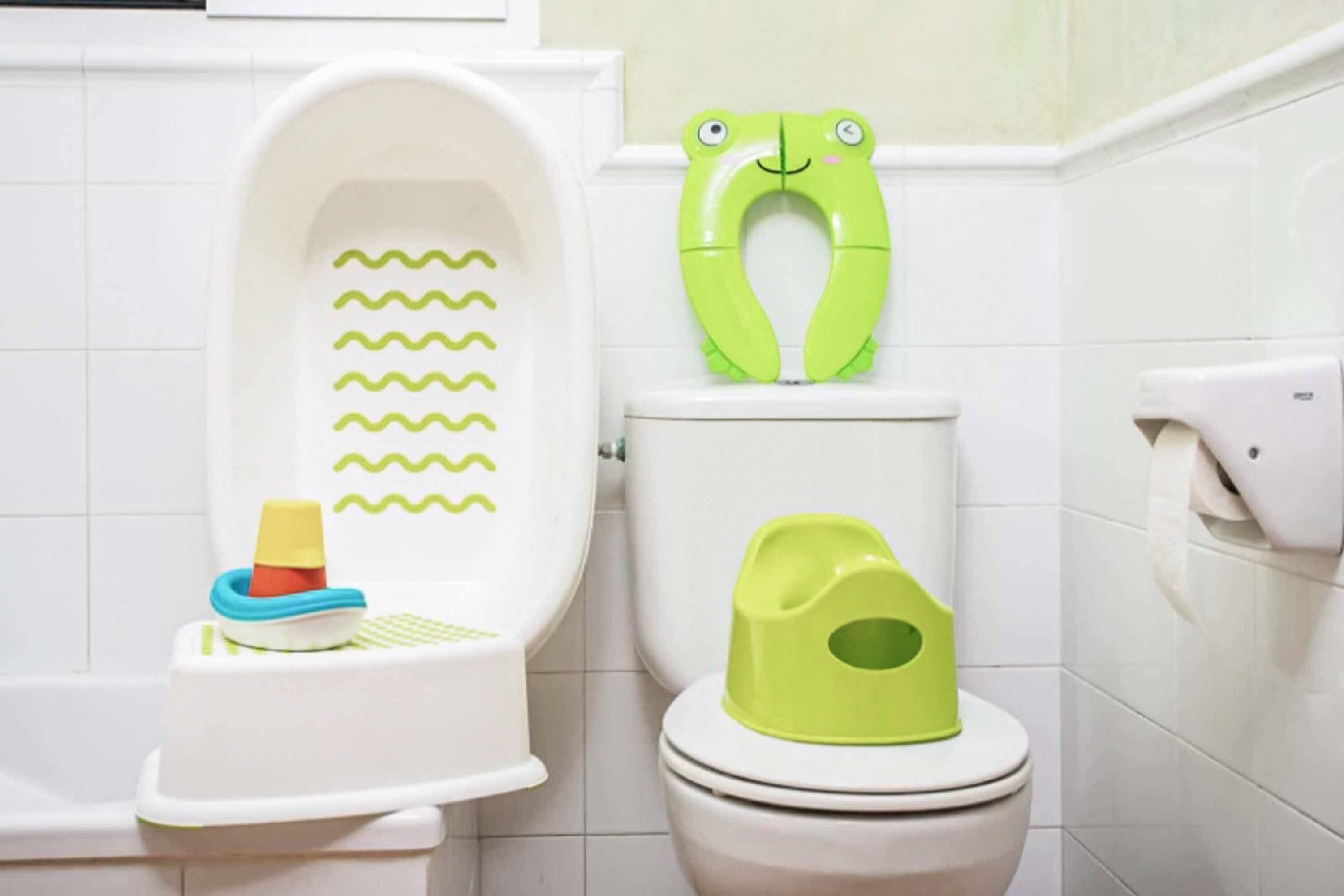 Een badkamer met een witte badkuip, een groene toiletbril en een toiletrolhouder aan de muur.