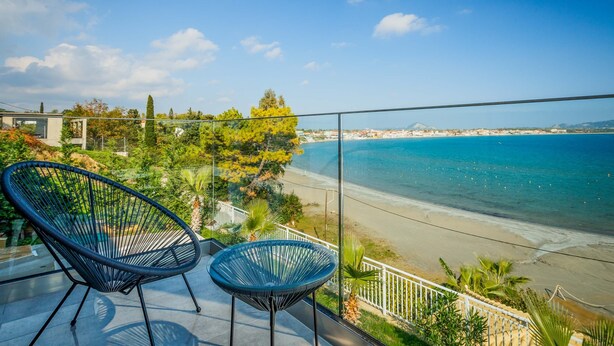 Un balcón con dos sillas con vista a la playa.
