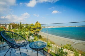 A balcony with two chairs overlooking a beach. - Bay View II - Three Bedroom Villa, Sleeps 6 (Agios Sostis)