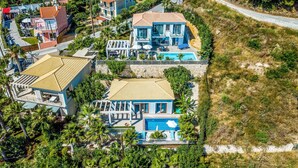 Vista aérea de una zona residencial con varias casas, una piscina y una calle.