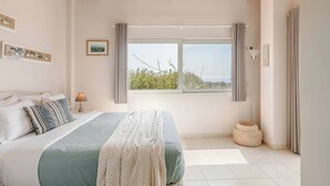 A bedroom with a bed, a window, a lamp, and a picture on the wall. - Mounda Beach Villa - Four Bedroom Villa, Sleeps 7 (Ionian Islands)