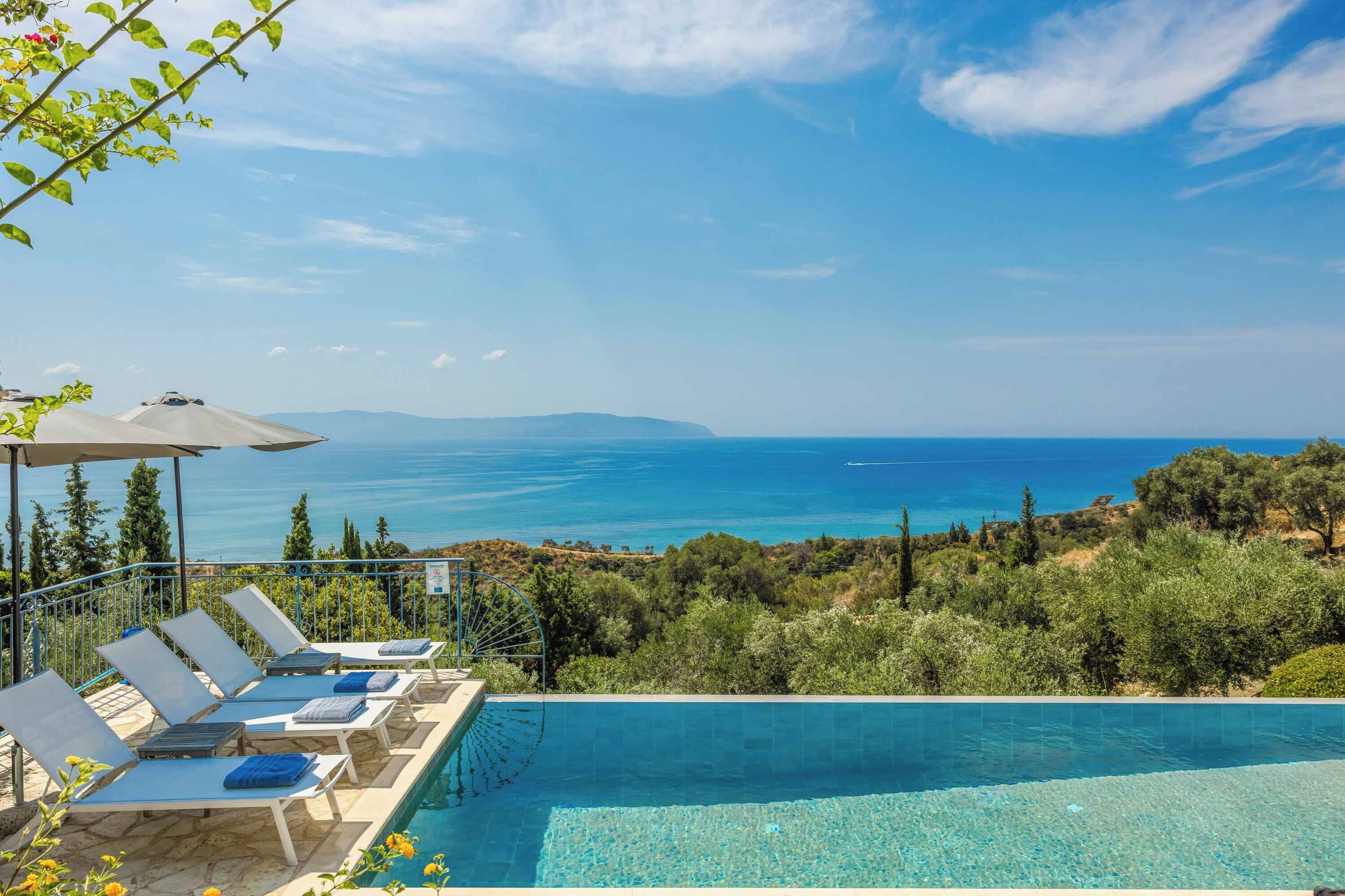Une piscine avec vue sur la mer, des chaises longues et une pergola.
