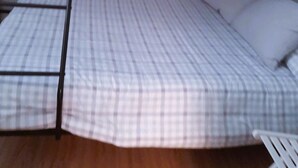 A bunk bed with a checkered mattress and a ladder. - Precioso Ático con Terraza Reformado (Mataró)