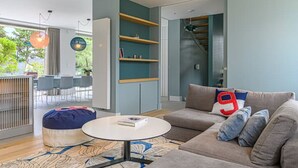 A modern living room with a sofa, a round coffee table, and a bookshelf. - Villa Contemporaine Bord de mer Trinité-sur-mer (La Trinité-sur-Mer)
