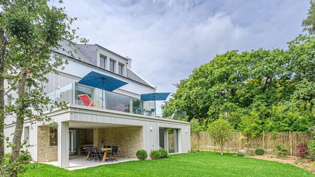 A modern house with a covered patio, a glass conservatory, and a well-maintained lawn. - Villa Contemporaine Bord de mer Trinité-sur-mer (La Trinité-sur-Mer)