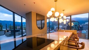 Une cuisine moderne dotée d’un grand îlot central, de grandes fenêtres et offrant une vue sur la ville.