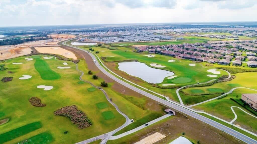 Vue aérienne d  ’un parcours de golf comportant plusieurs greens, des bunkers et des obstacles d’eau.