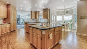 A spacious kitchen with wooden cabinets, a central island, and a large window providing natural light. - Water-view estate with on-site entertainment & 3 kitchens - events welcome (Clinton)