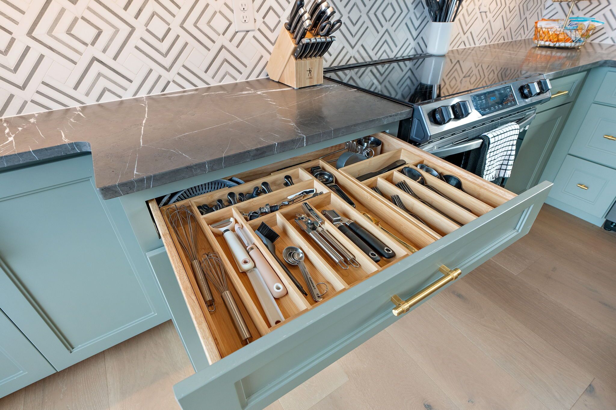 Una cucina con un organizer a cassetti pieno di utensili.