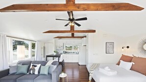 Un intérieur moderne comprenant un canapé, un lit, un coin repas et une cuisine.