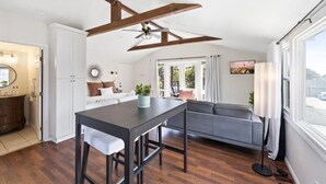 Une cuisine moderne avec un coin repas, un ventilateur de plafond et une vue sur l’extérieur.