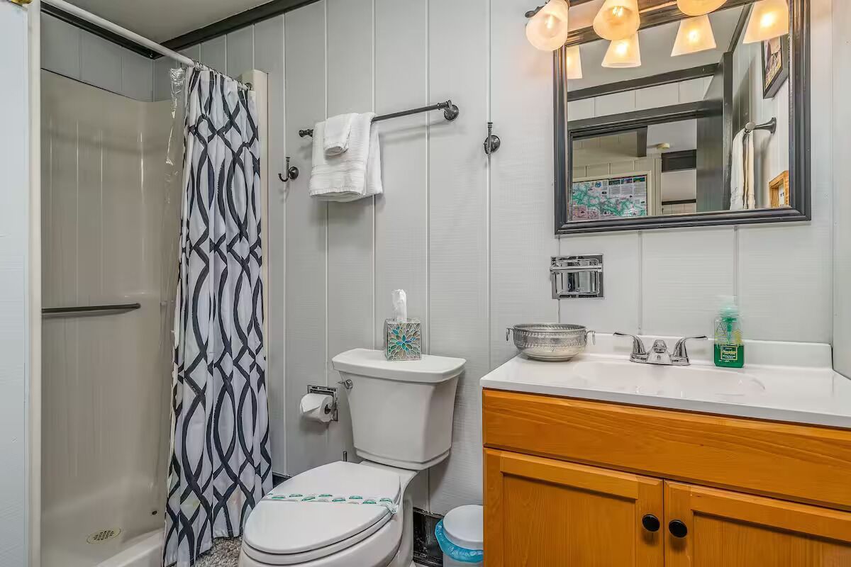 Une salle de bain équipée d’une douche, de toilettes, d’un lavabo et d’un meuble-lavabo.