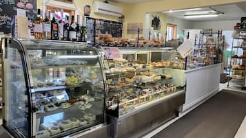 A bakery display case with various baked goods and a chalkboard menu.