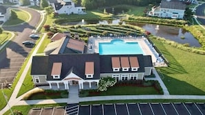 A large building with a swimming pool, surrounded by a well-maintained lawn and a parking lot. - Rehoboth Beach Home with Pool and Dedicated Workspace! (Rehoboth Beach)