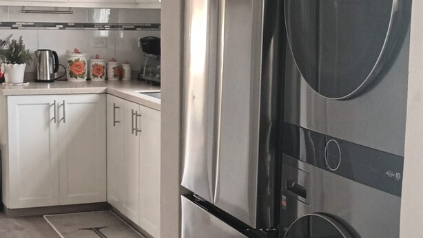 A modern kitchen with white cabinets, stainless steel appliances, and a kitchen island.