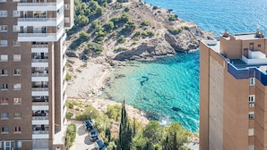 Un hotel frente al mar con varios pisos, balcones y vistas al océano.