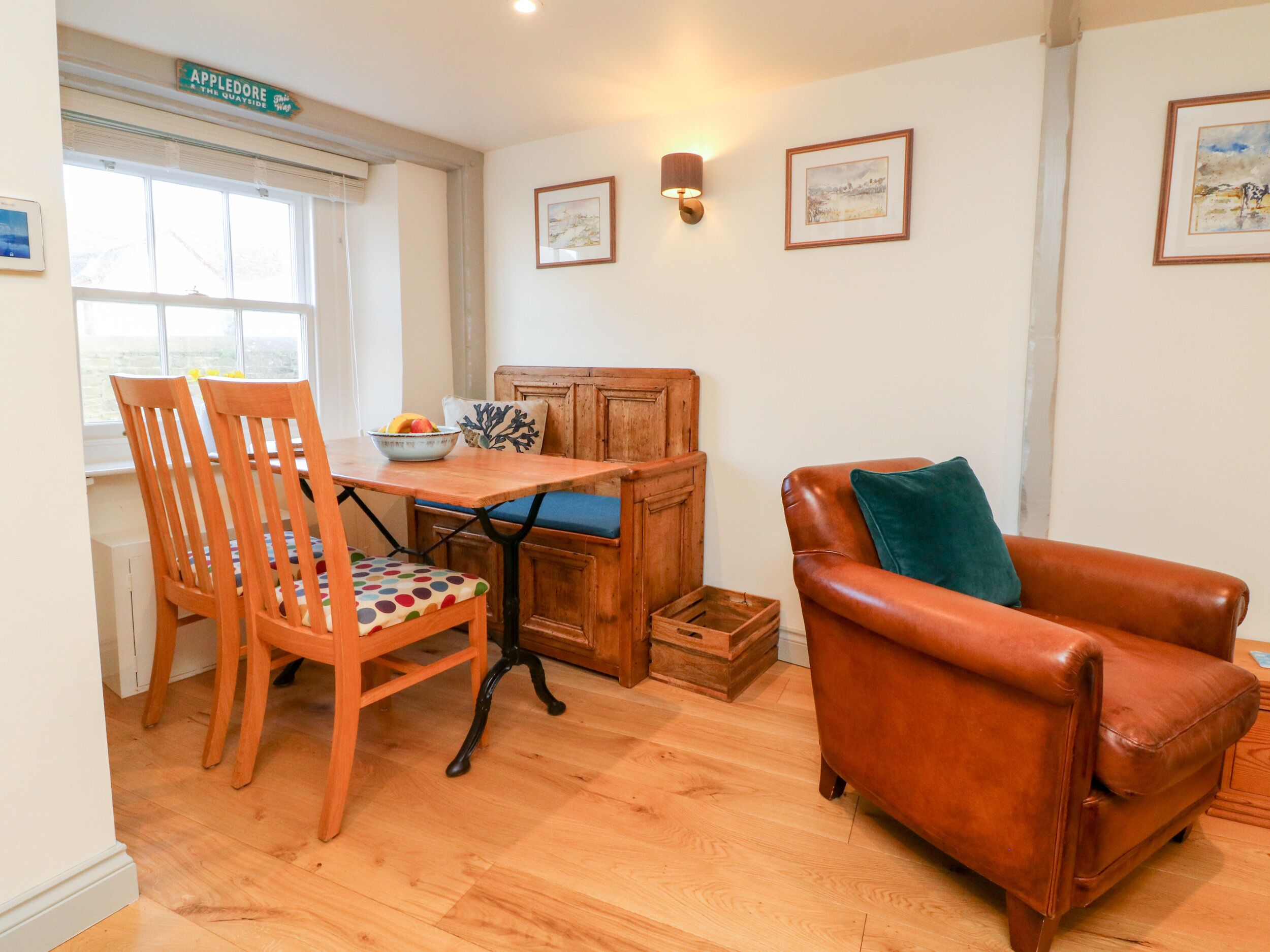 A cozy room with a wooden dining table, a brown leather armchair, and a wooden bench.