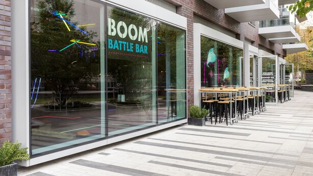 A modern building with a glass facade and the name "BOOM BATTLE BAR" on the window. - Aldgate London City Boutique Studio 3 (London)