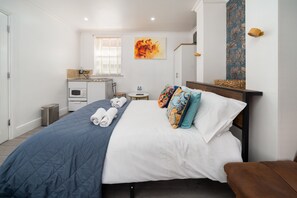 A hotel room with a bed, a small kitchenette, a bathroom, and a window with blinds. - Aldgate London City Boutique Cosy Studio 4 (London)