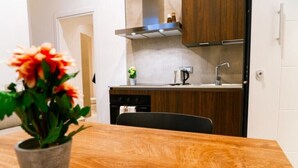 A modern kitchen with wooden cabinets, a stainless steel range hood, and a built-in dishwasher.