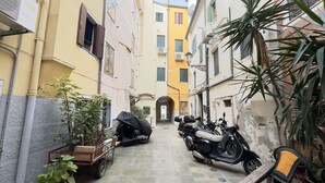 Um beco estreito com scooters estacionadas e um carrinho de mercadorias.