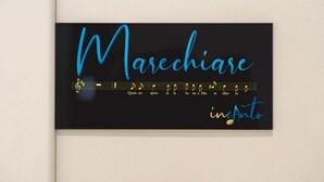A black business card with the name "Marechiara" in blue cursive font, musical notes, and the word "inAnto" in yellow cursive font.