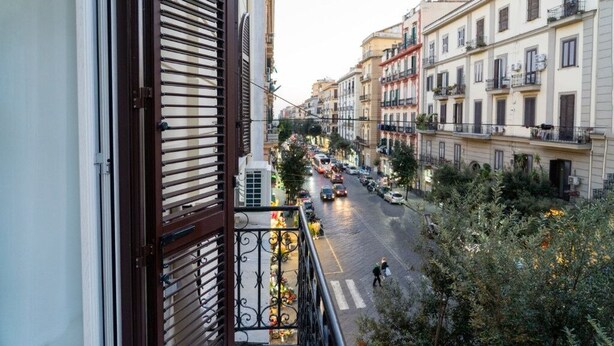 A balcony with a view of a busy street and buildings.