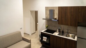A compact kitchen with a built-in oven, a sink, and a wooden cabinet.