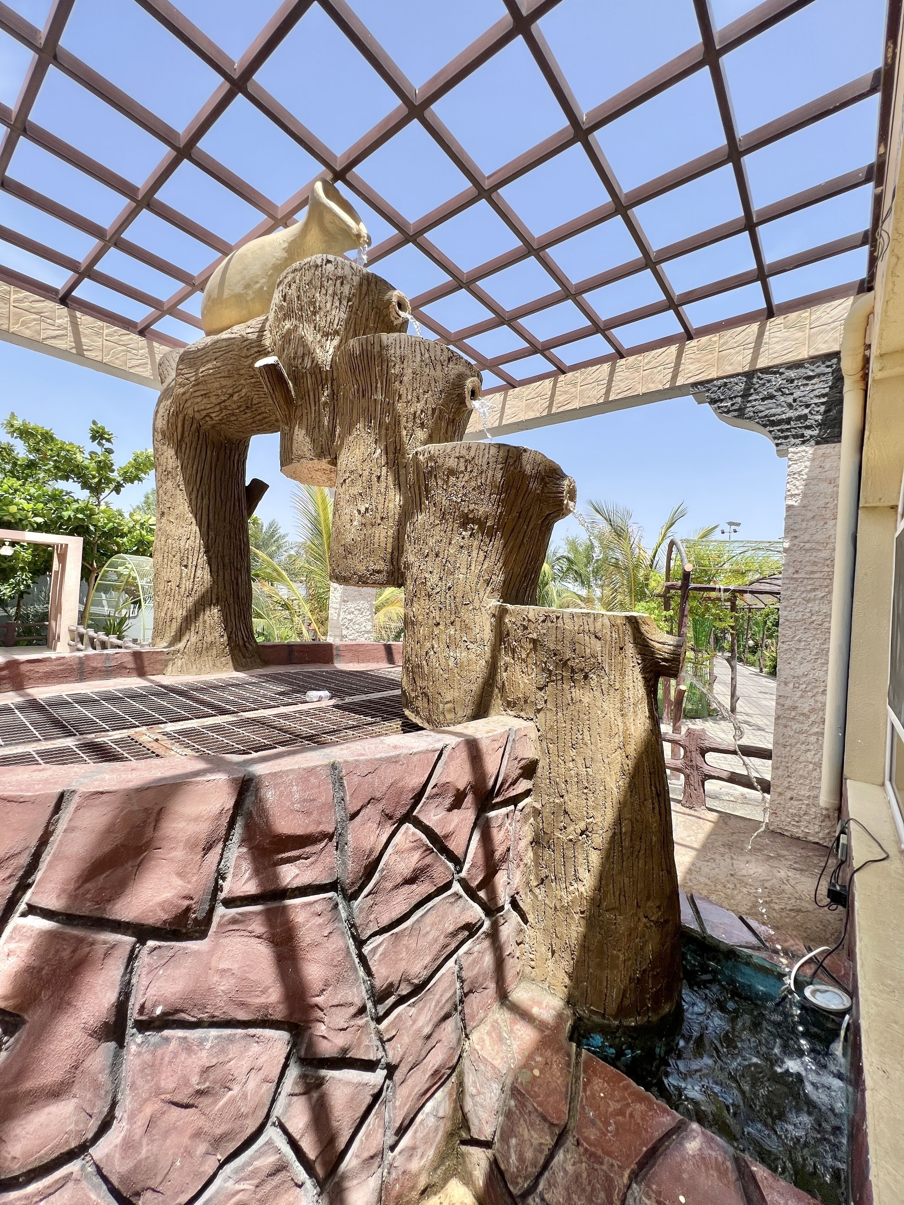A water feature with a stone sculpture and a tiled floor.